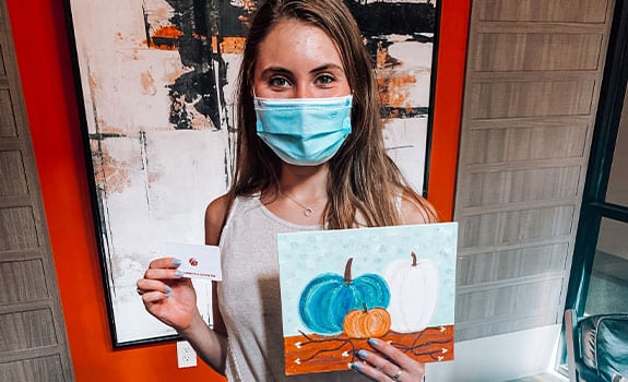 College Student holding Their Painting